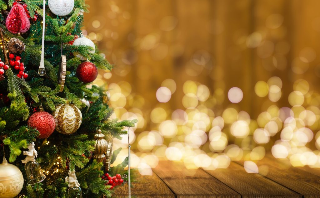 Side of Christmas tree with blurred lights in the background