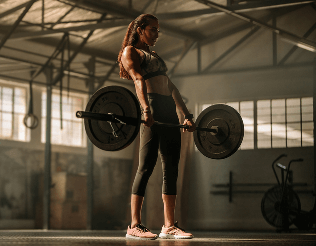 Woman deadlifting heavy barbell